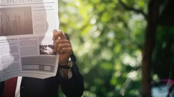 Reading Newspaper on Park Bench